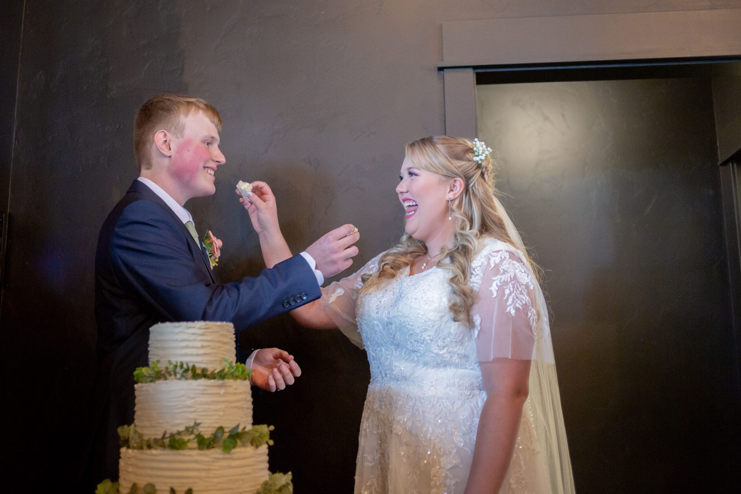 bride and groom feeding each other wedding cake
