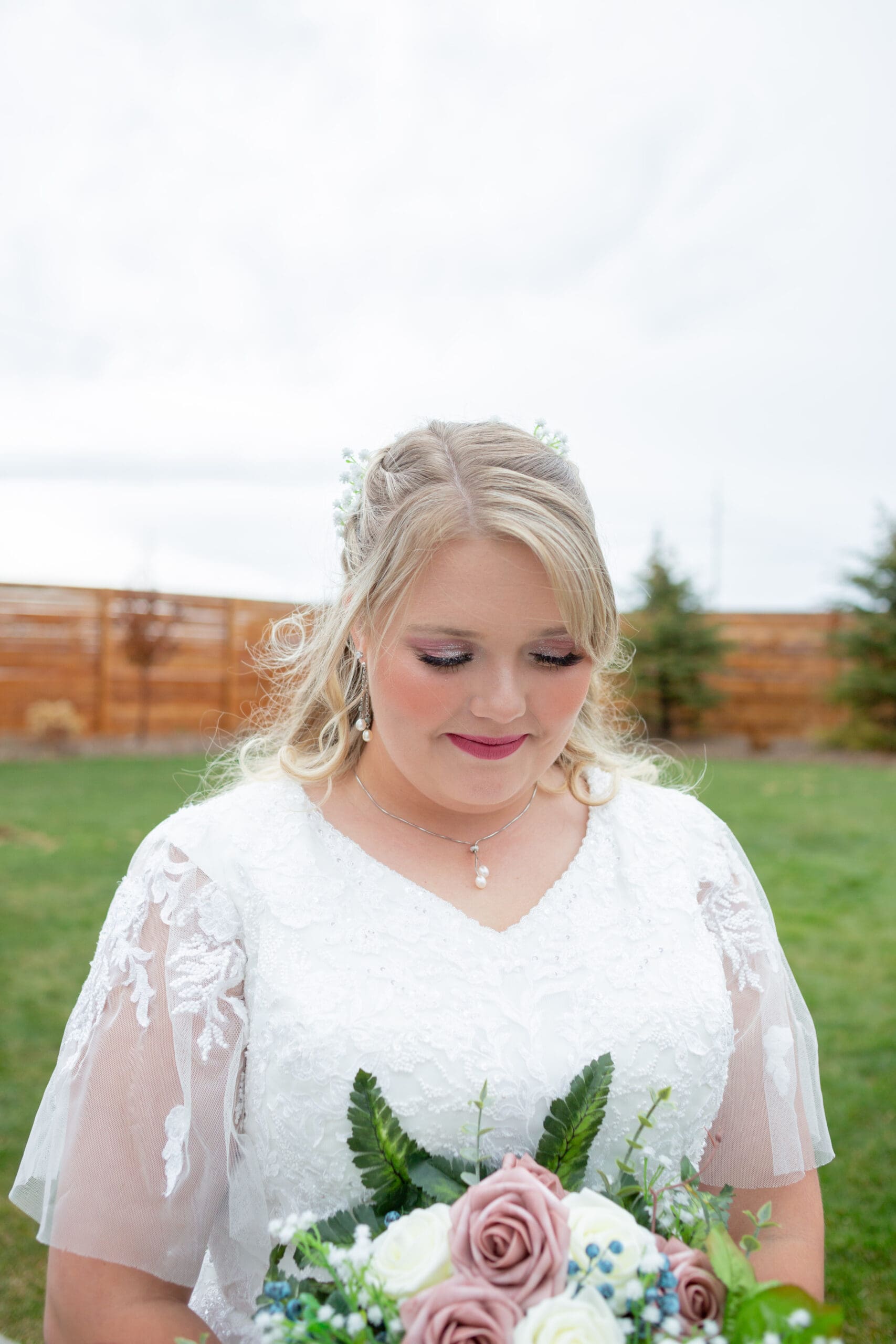 bride looking down at her wedding bouquet