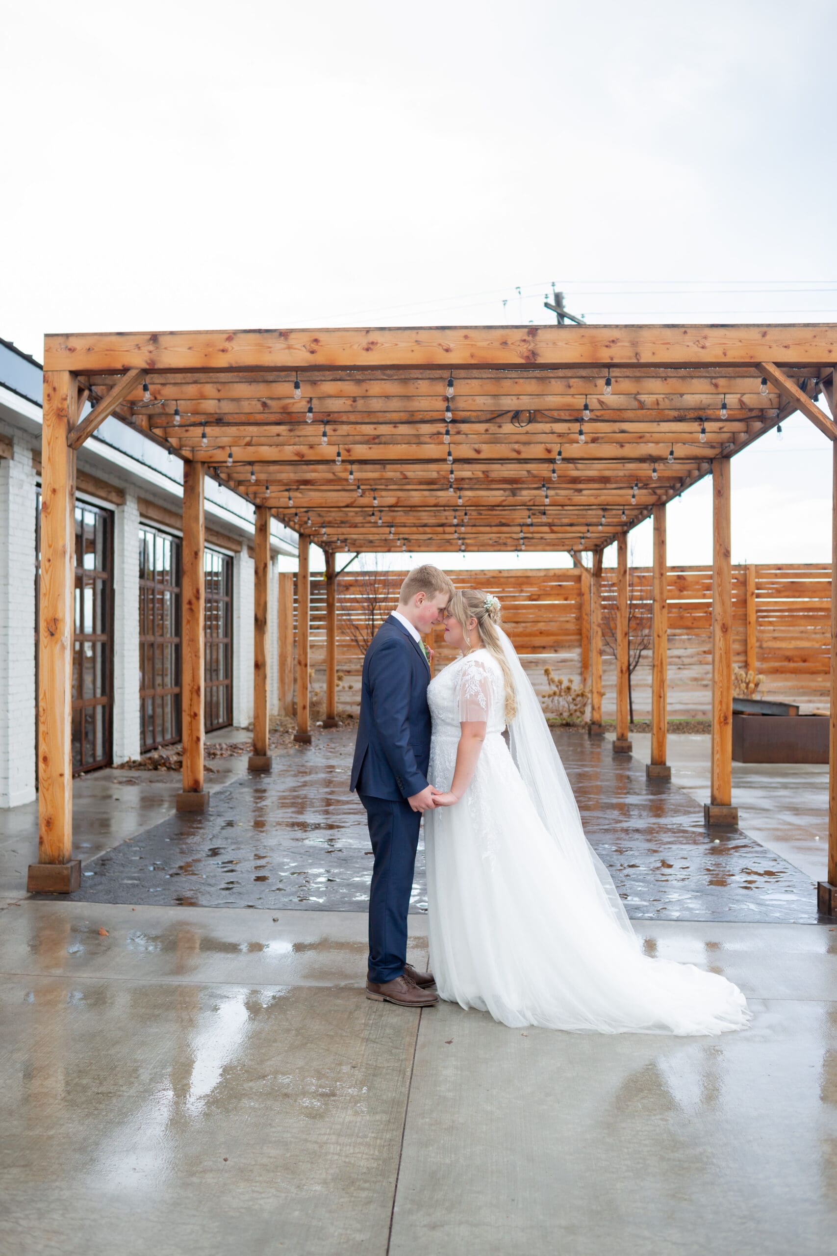 bride and groom facing each other holding hands with their foreheads together