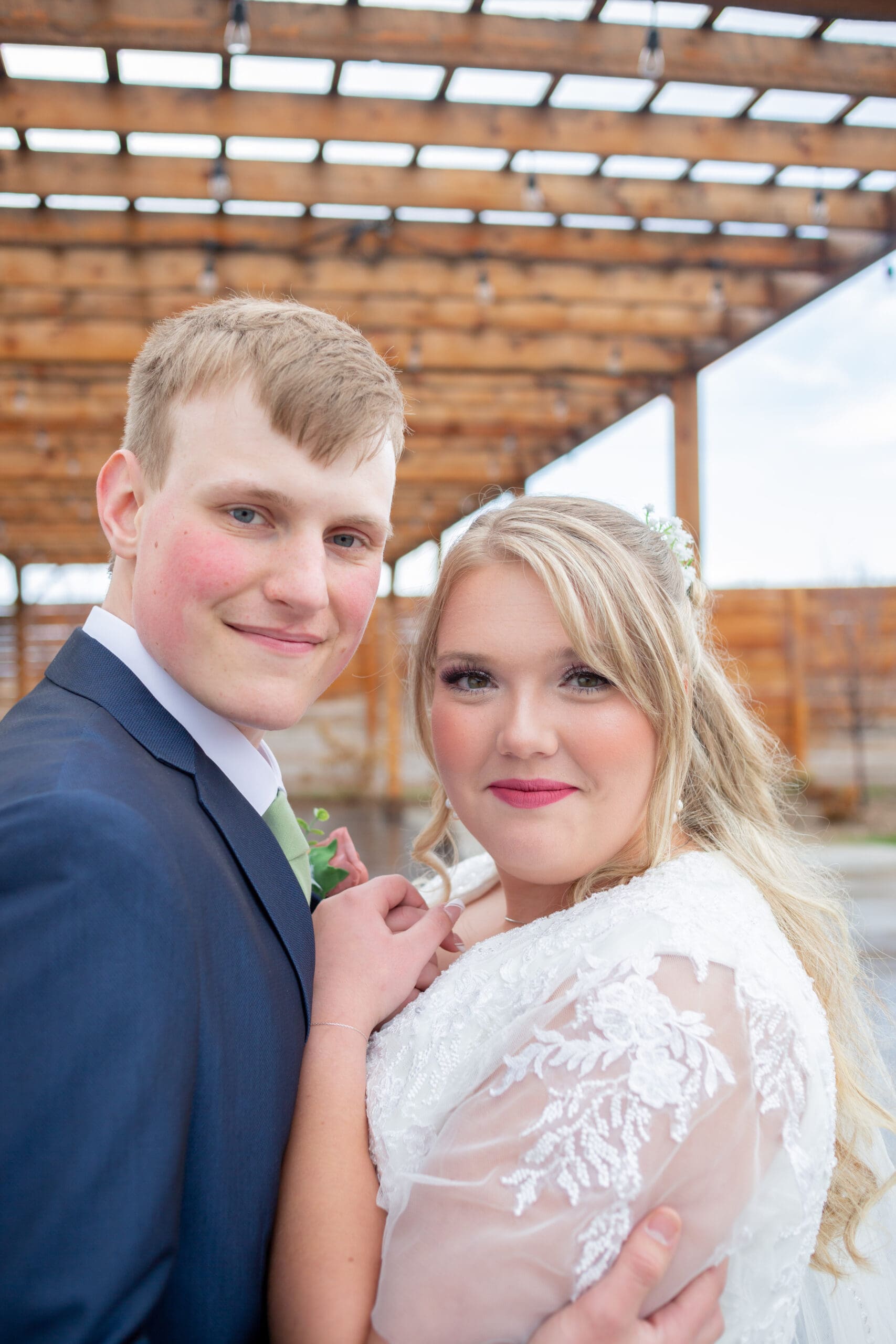 bride and groom snuggling looking at the camera