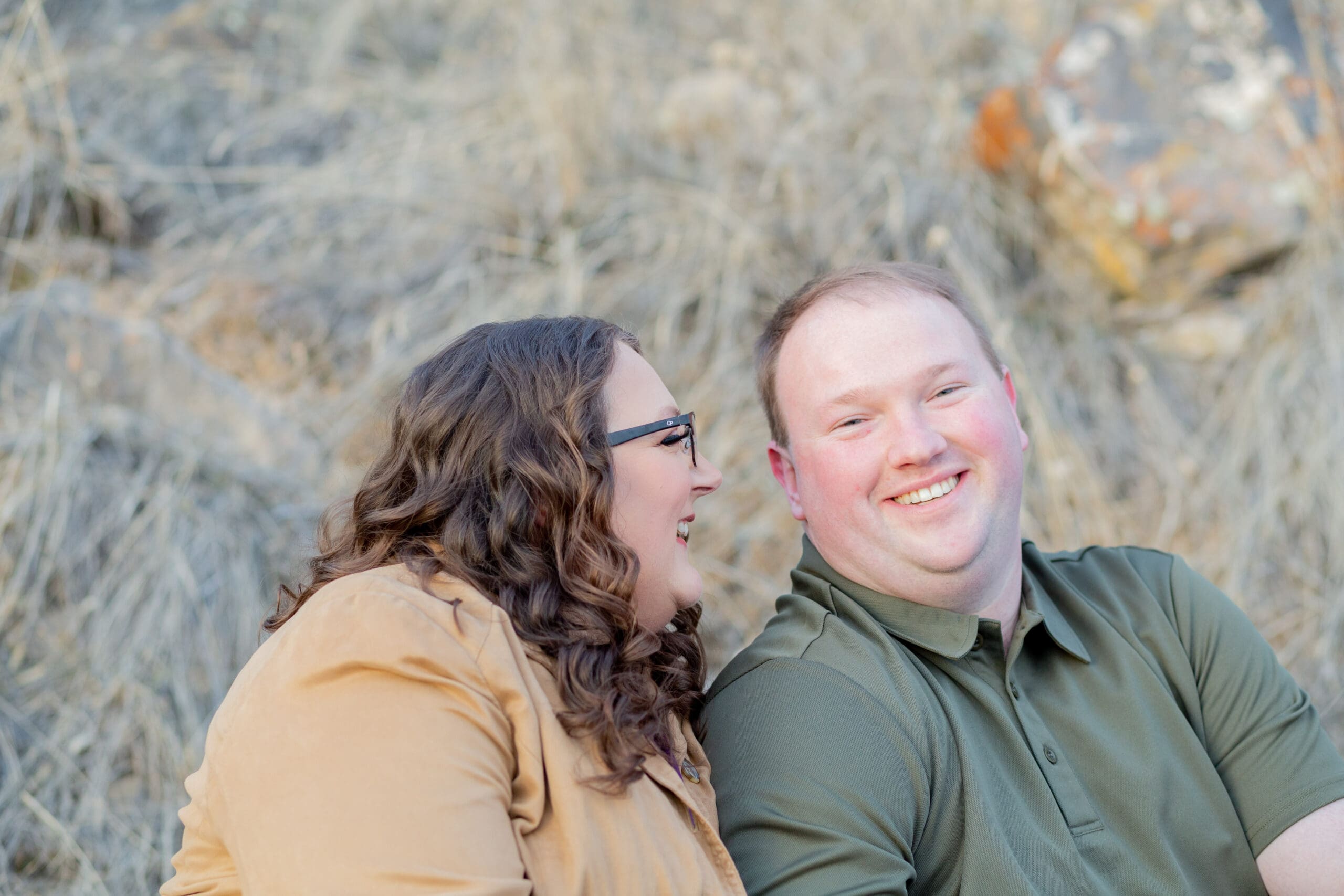 engaged-couple-sitting-next-to-each-other-and-laughing
