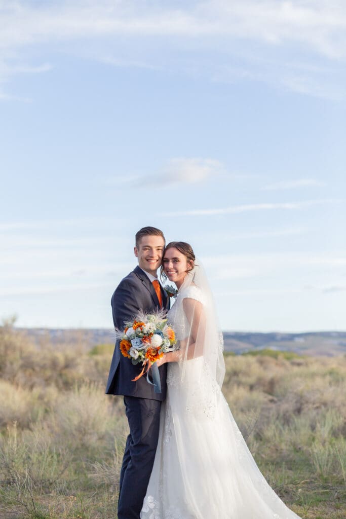 bride-and-groom-hugging-and-looking-at-camera
