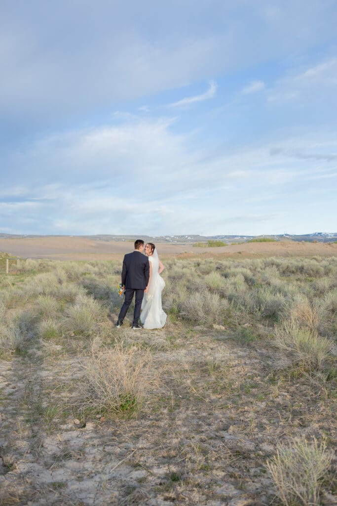 bride-and-groom-walking-through-sagebrush