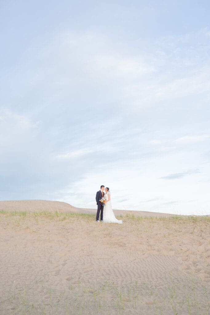 PNW Elopement Photographer captures bride and groom embracing in sandy beach after they chose to elope in the PNW