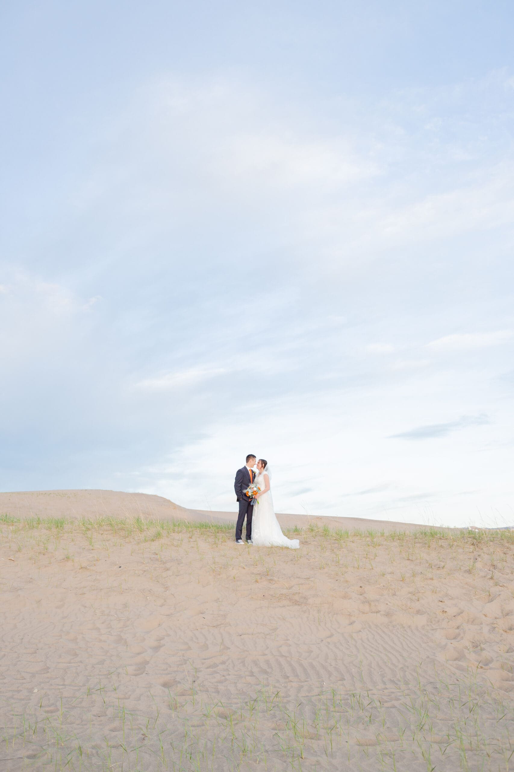 PNW Elopement Photographer captures bride and groom embracing in sandy beach after they chose to elope in the PNW
