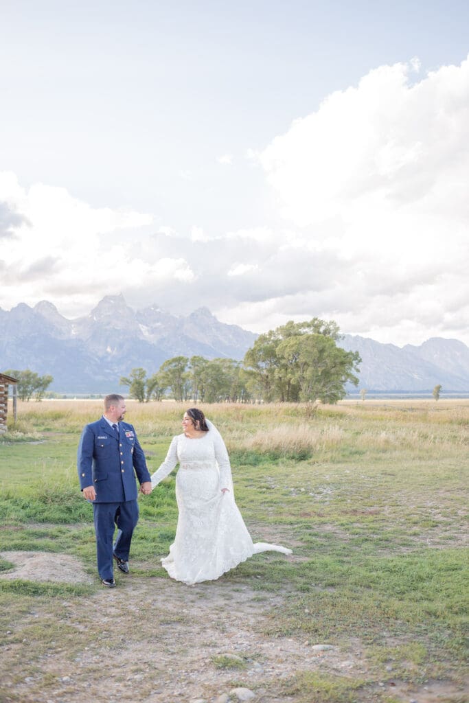 PNW Elopement Photographer captures bride and groom walking hand in hand during outdoor elopement