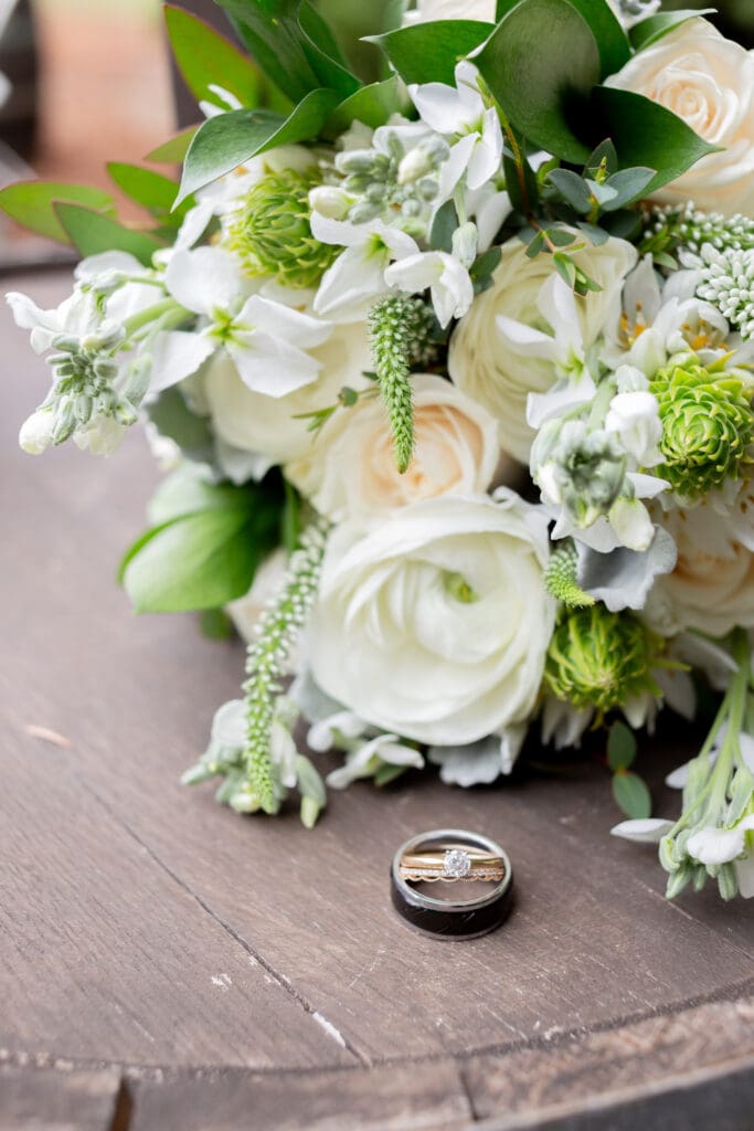 PNW Elopement Photographer captures bridal bouquet with rings sitting alongside