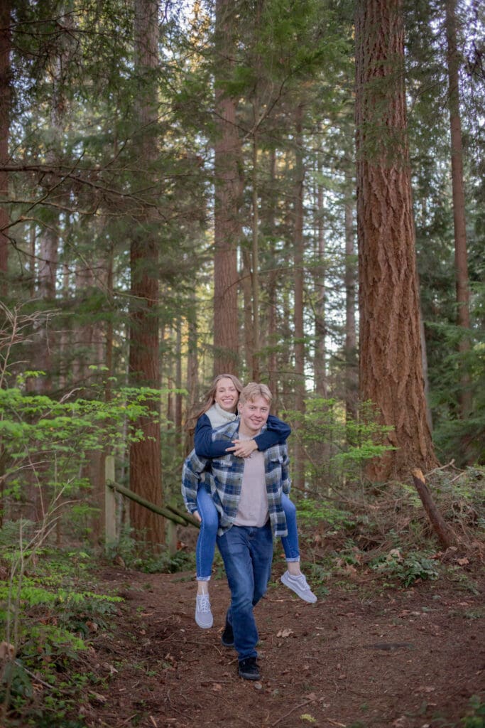 guy-holding-girl-piggy-back-walking-through-the-forest