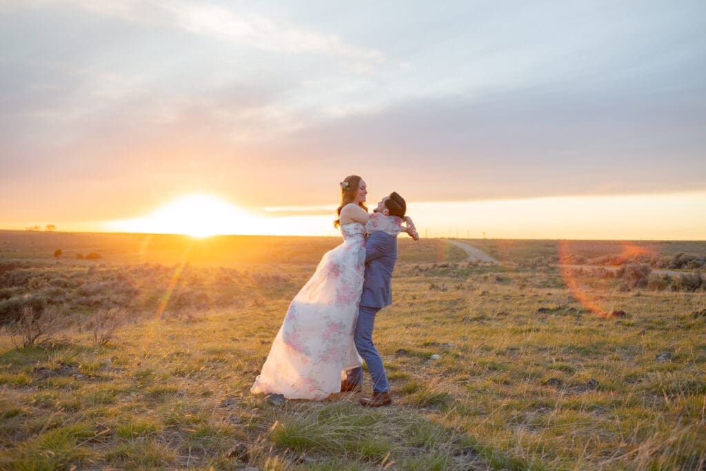 PNW Elopement Photographer captures groom lifting bride at sunset after intimate elope at PNW 
