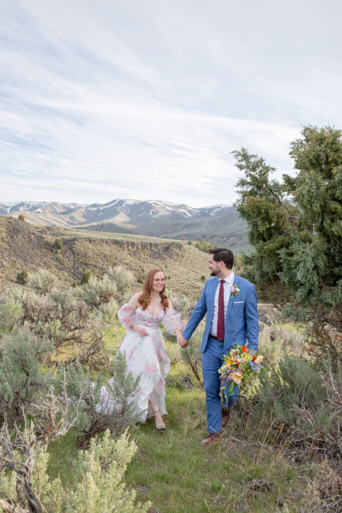 Seattle Wedding Photographer captures bride and groom walking hand in hand in the mountains after their Seattle Destination Wedding