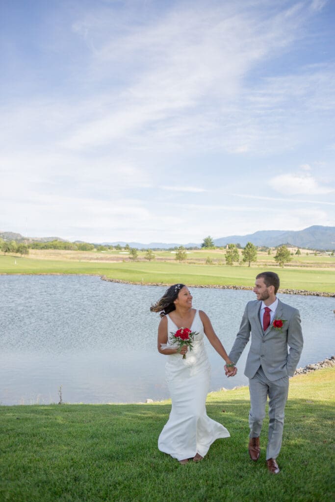 PNW Elopement Photographer captures bride and groom walking together alongside lake