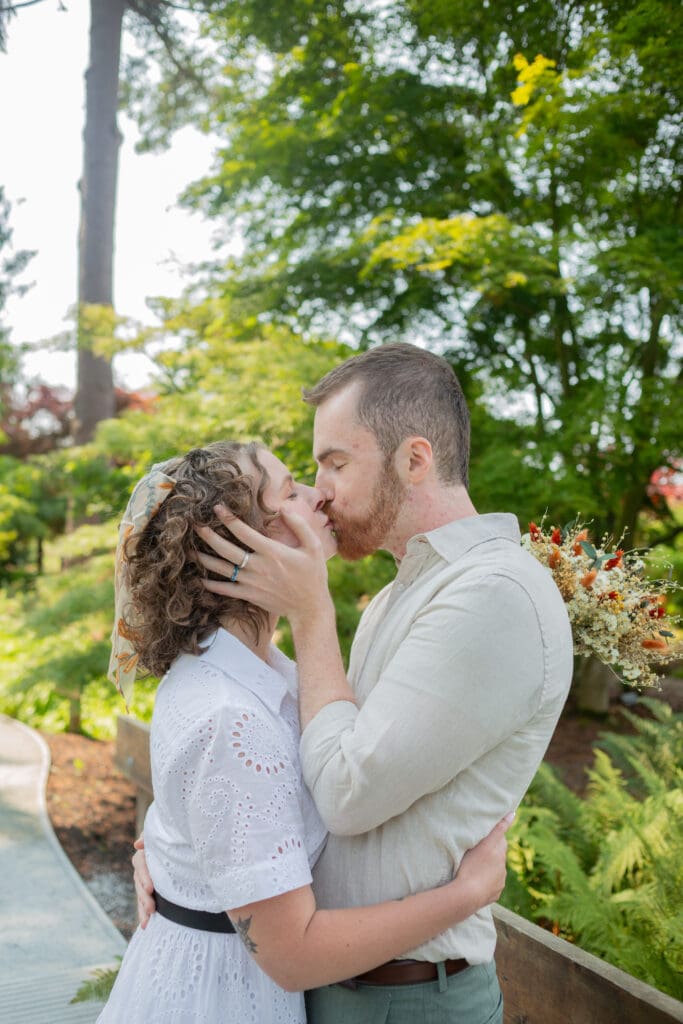 Bride and groom kissing in Seattle gardens before their Seattle Wedding
